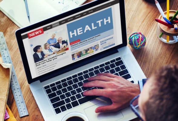 Overhead image of a laptop screen displaying a news site with the large words health on it